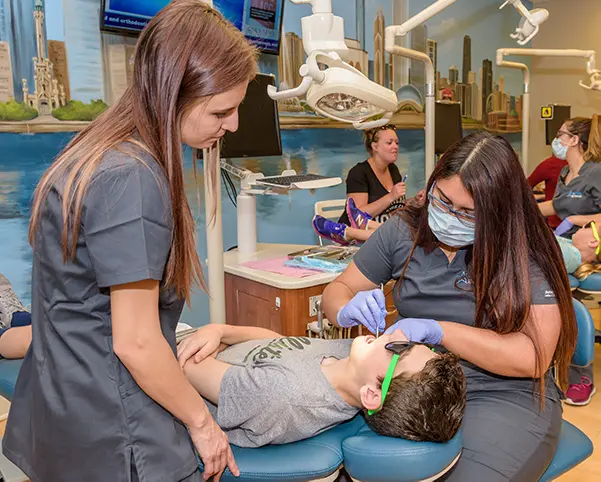Two team member from Star Smiles Orthodontics and Pediatric Dentistry, check up child patient for children orthodontic in Bloomingdale and Naperville, IL.