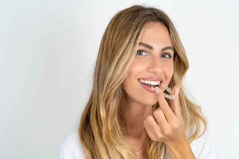 blonde woman holding invisalign clear aligners as one of the alternatives to braces in Bloomingdale and Naperville, IL