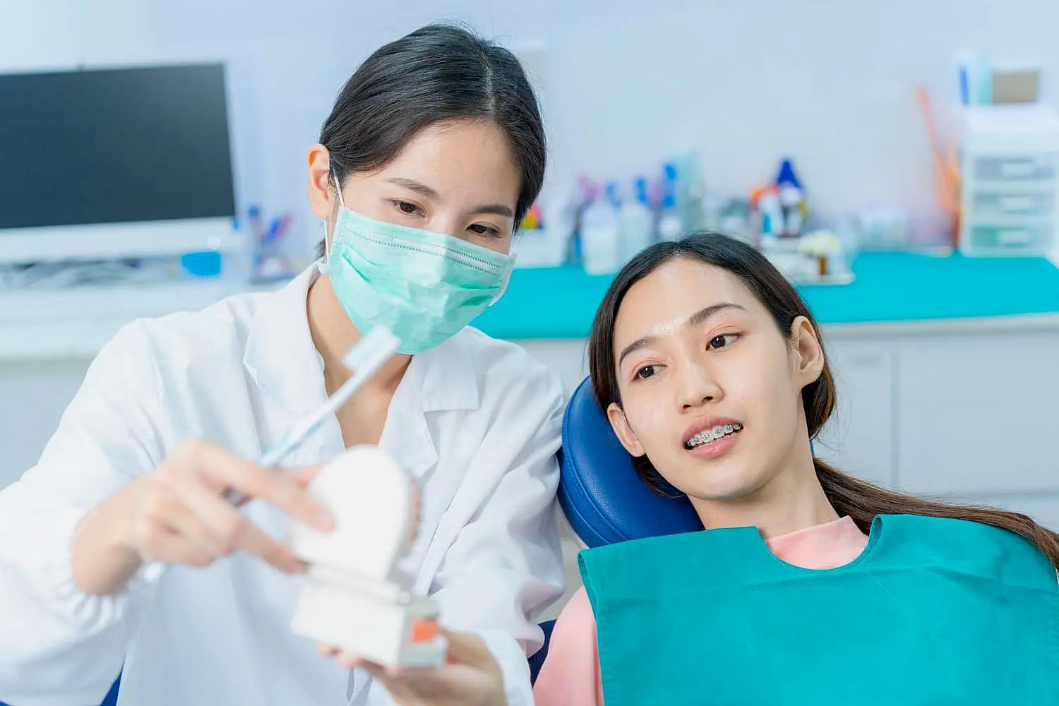 A dentist discuss about long-term management after tongue thrust treatment to patient while consultation in medical office in Bloomingdale and Naperville, IL.