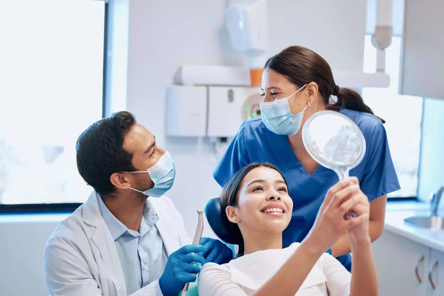 A dentist examines with orthodontic appliances modern, to young woman sitting in a dental chair during look at result her braces tratment at Star Smiles Orthodontics and Pediatric Dentistry in Bloomingdale, IL.