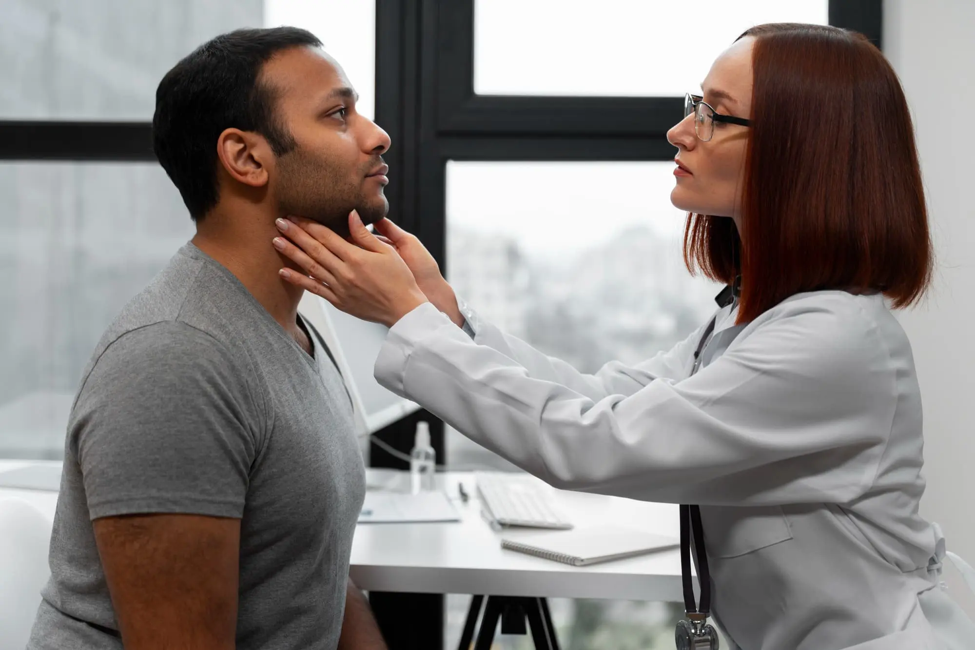 A doctor checks the throat of a seated man patient, discussing about important jaw surgery options in Bloomingdale and Naperville, IL.