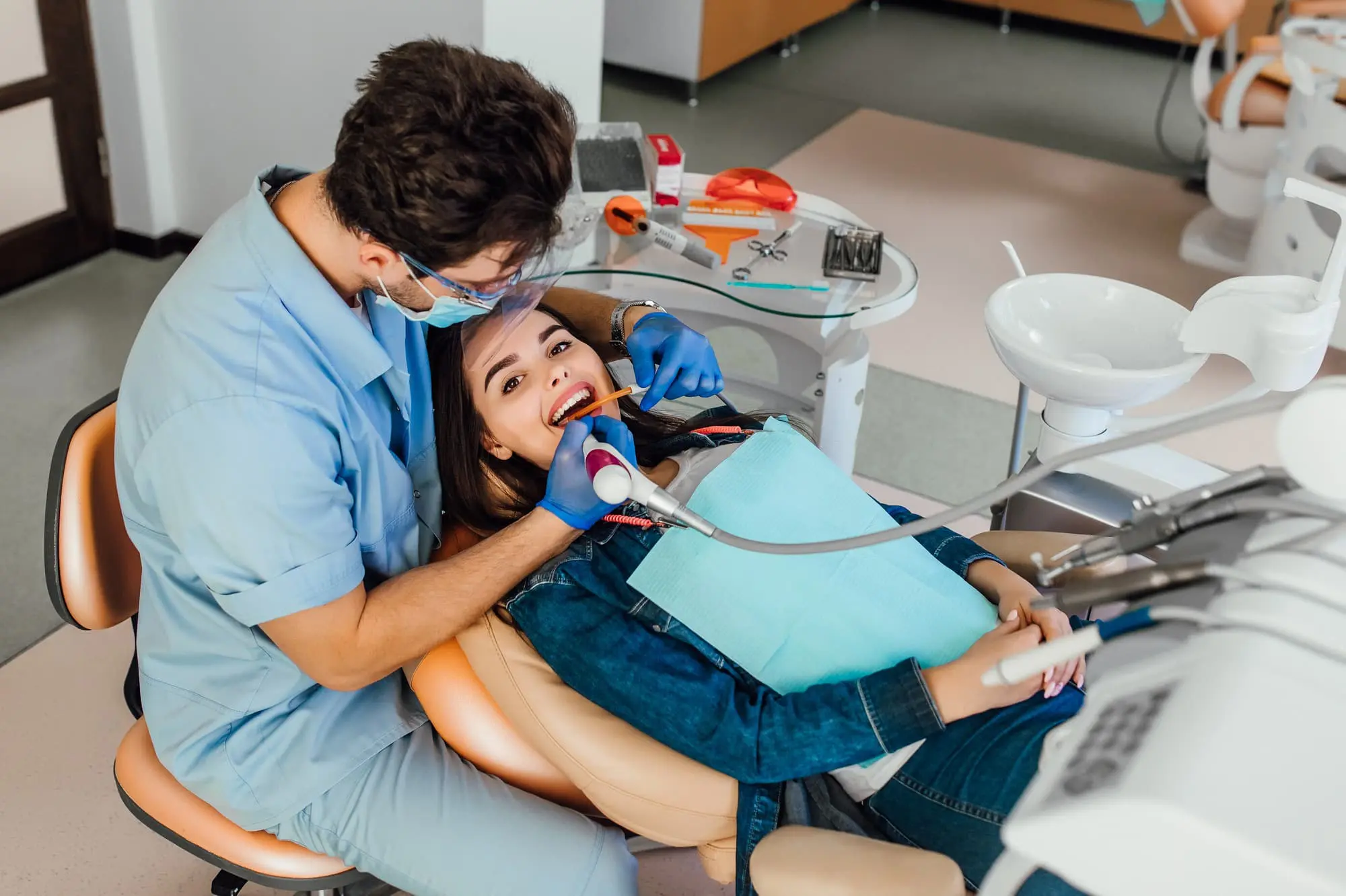 Young female patient with open mouth examining dental inspection by dentist with orthodontic appliances modern in Naperville, IL.