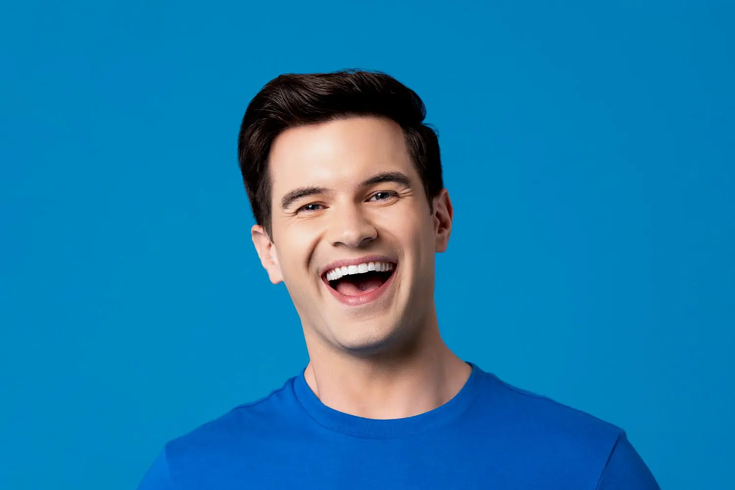 A smiling people in a blue shirt, radiating confidence after her treatment overbite in Bloomingdale and Naperville, IL.