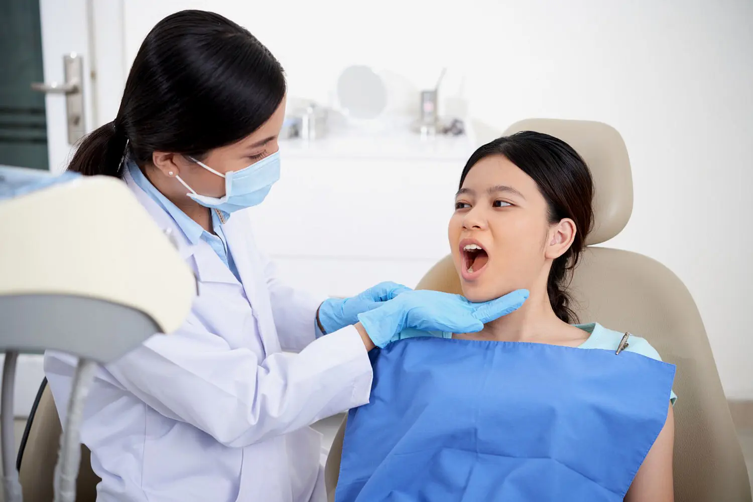 A child woman smile sitting in a dental chair during appointments with local children’s orthodontist in Bloomingdale and Naperville, IL.