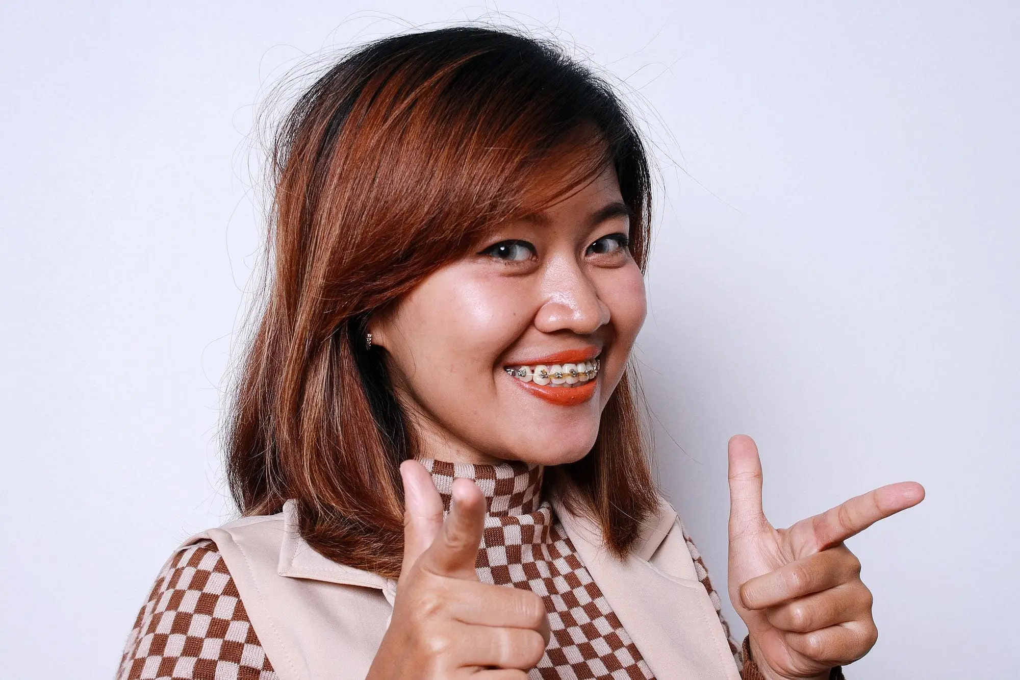 A woman smiling person with metal braces from Star Smiles Orthodontics and Pediatric Dentistry surprised with the her result dental braces treatment in Bloomingdale and Naperville, IL.