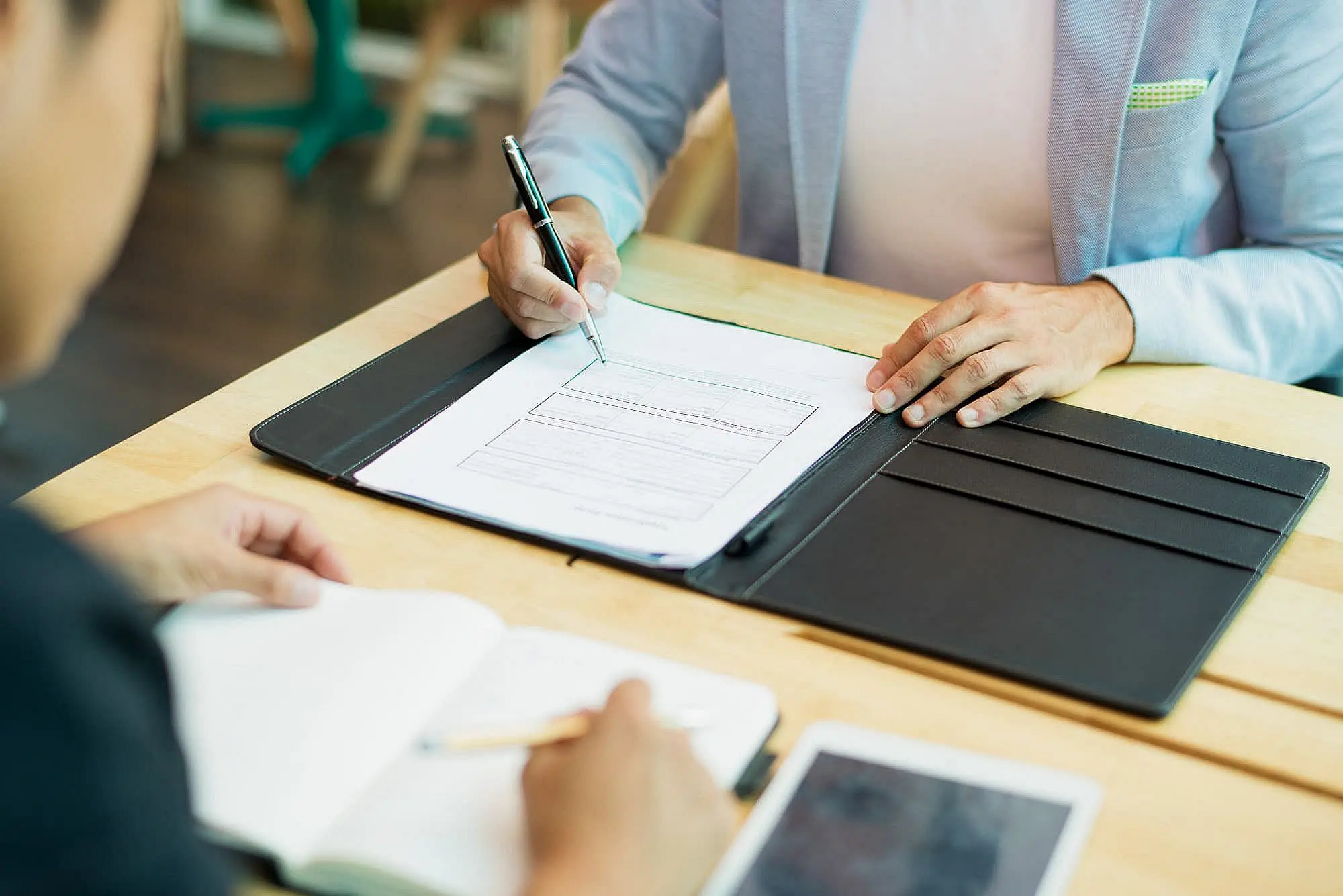A person fill out Invisalign insurance coverage application form on a wooden table in Bloomingdale and Naperville, IL.