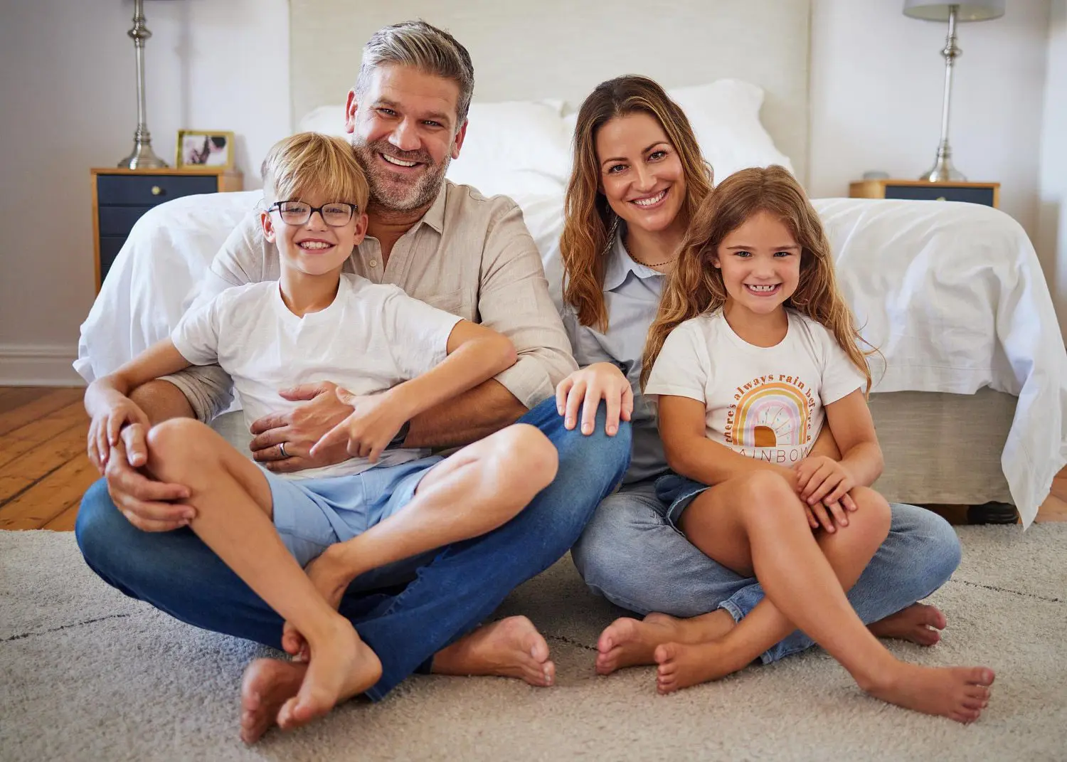 Happy family in living room including father and mother, feel benefit Orthodontic Insurance at Star Smiles Orthodontics and Pediatric Dentistry in Bloomingdale and Naperville, IL.