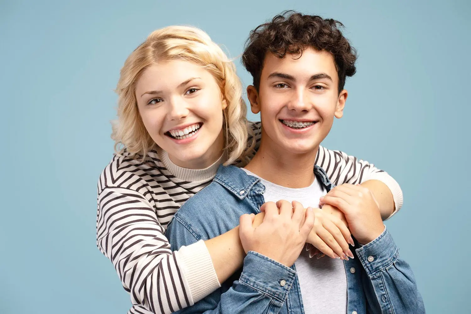 Portrait of attractive smiling young couple boyfriend with braces and girlfriend, show off with dental braces from Star Smiles Orthodontics and Pediatric Dentistry in Bloomingdale, IL.