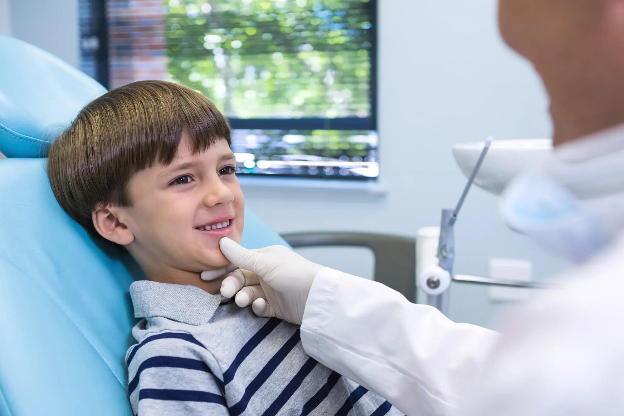 A child in a dental chair with a children’s orthodontist examining their teeth at Star Smiles Orthodontics and Pediatric Dentistry in Bloomingdale and Naperville, IL.