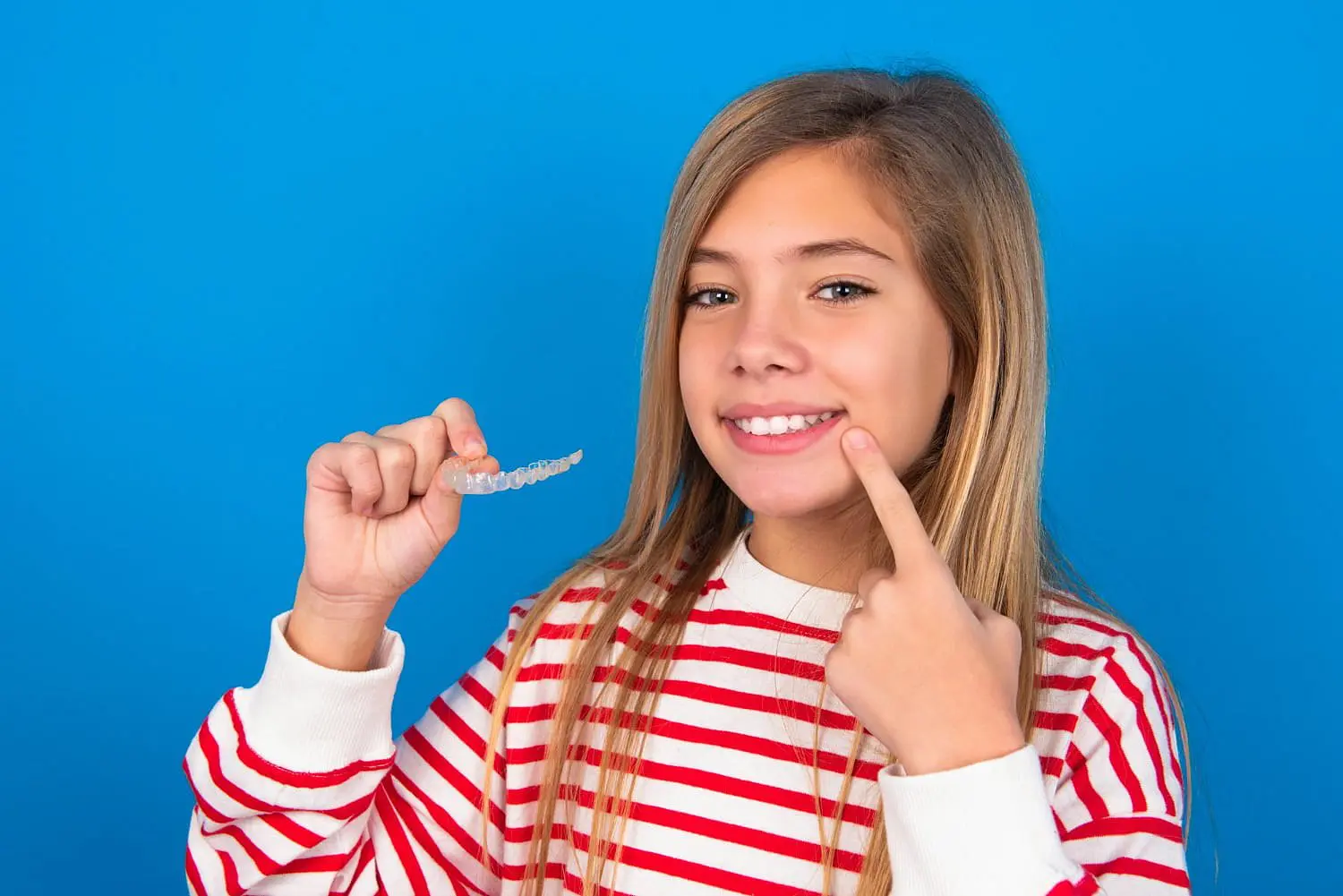 A child hold clear aligners from top-rated children’s orthodontist in Bloomingdale and Naperville, IL.