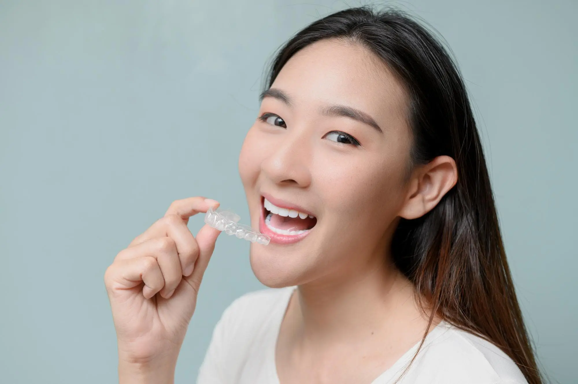 A woman holds Invisalign from trusted orthodontist like Star Smiles Orthodontics and Pediatric Dentistry provide with affordable price in Naperville, IL.