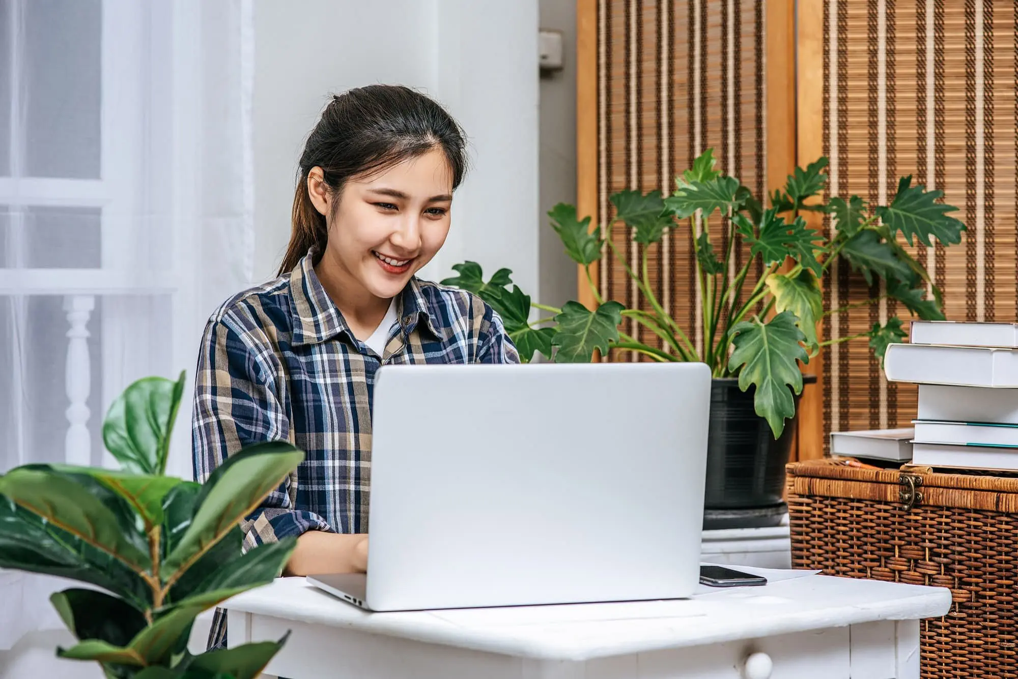 A woman at a table smiles, looking for affordable braces in internet and choose Star Smiles Orthodontics and Pediatric Dentistry in Bloomingdale and Naperville, IL for solution.