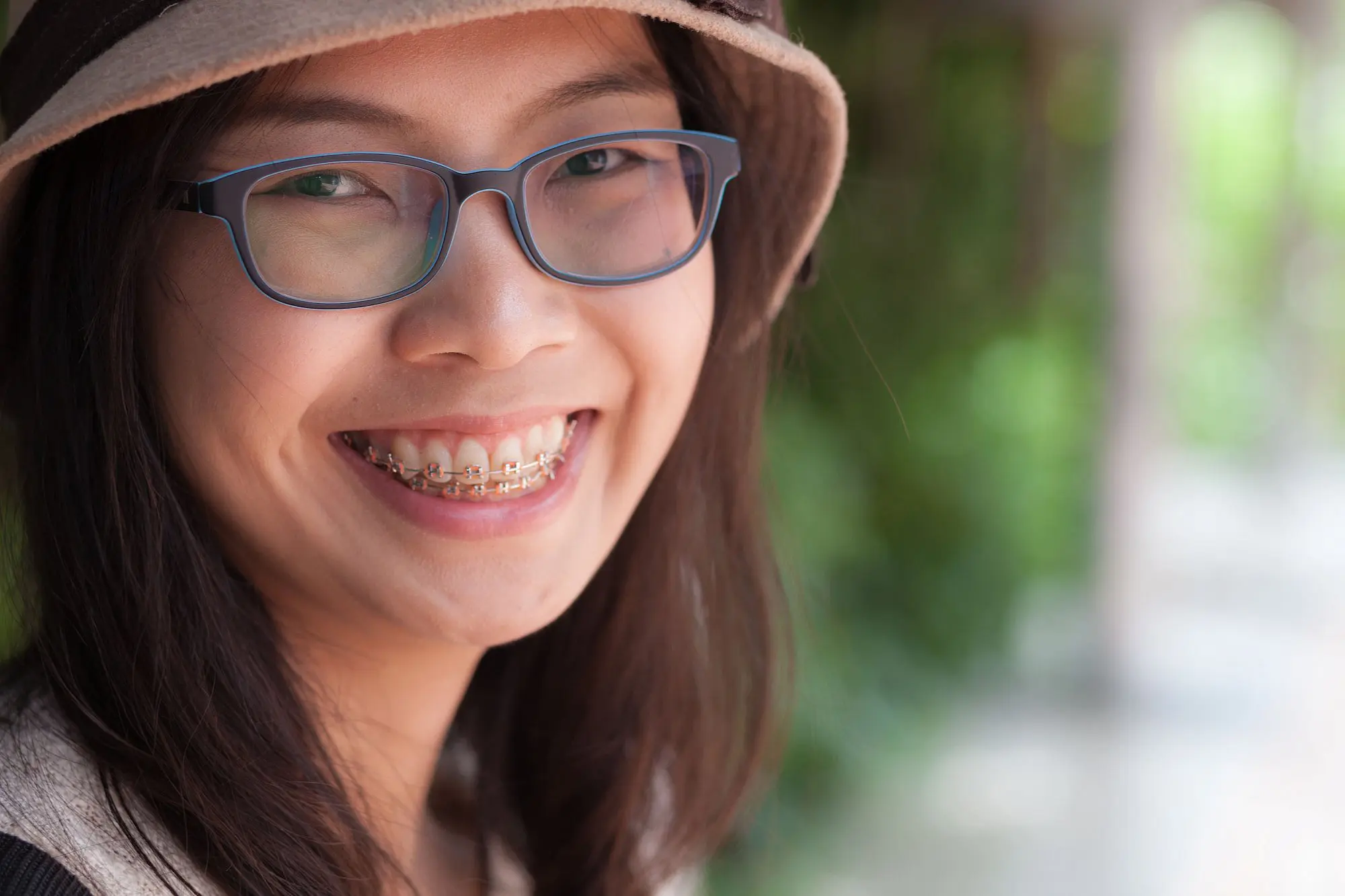 A woman with adult braces smiles understanding the importance of Smile Aesthetics from dental treatment in Bloomingdale and Naperville, IL.