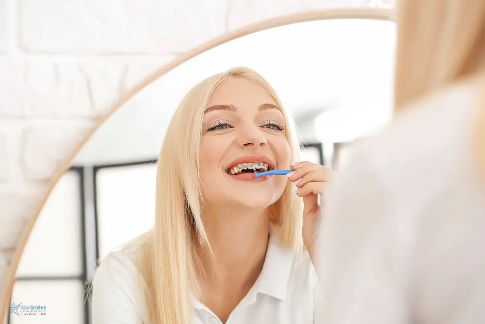 young woman metal braces toothbrush home - How to Floss with Braces in Bloomingdale and Naperville, IL 