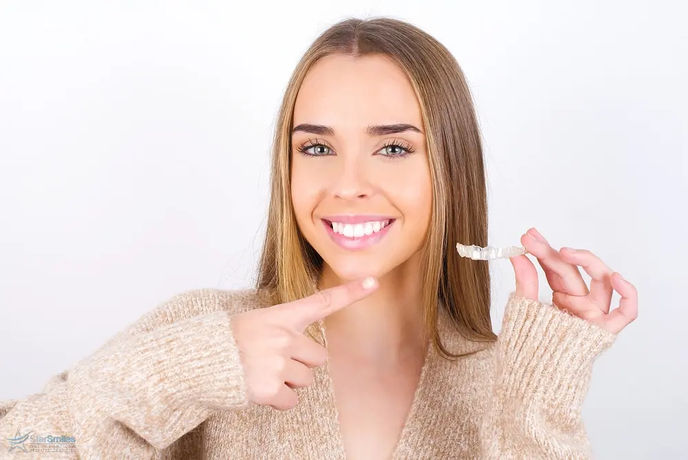 young woman holding invisalign clear aligners - How Does Invisalign Work in Bloomingdale, IL 